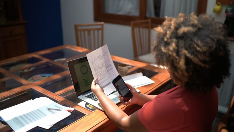 A person uses a mobile app to scan paper documents.