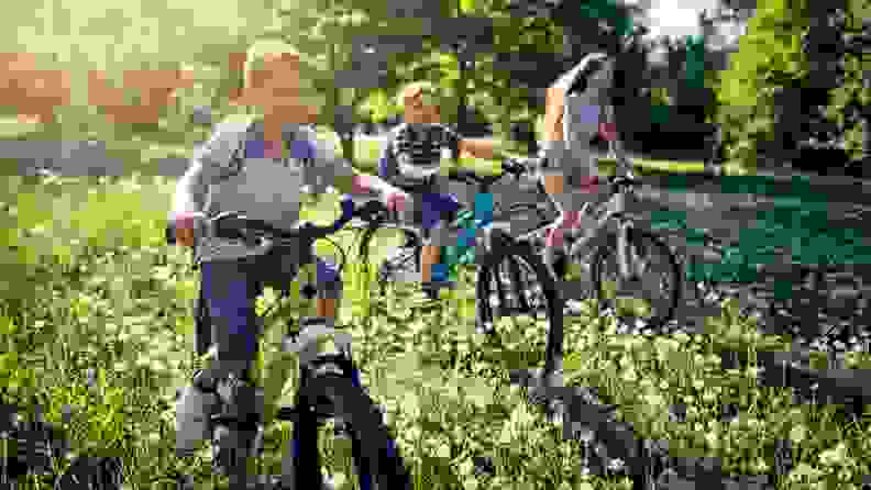 A bunch of kids ride through a field on their bikes