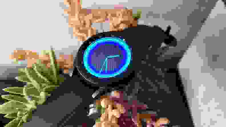 The front of the Galaxy Watch 4, showing a neon blue watch face.