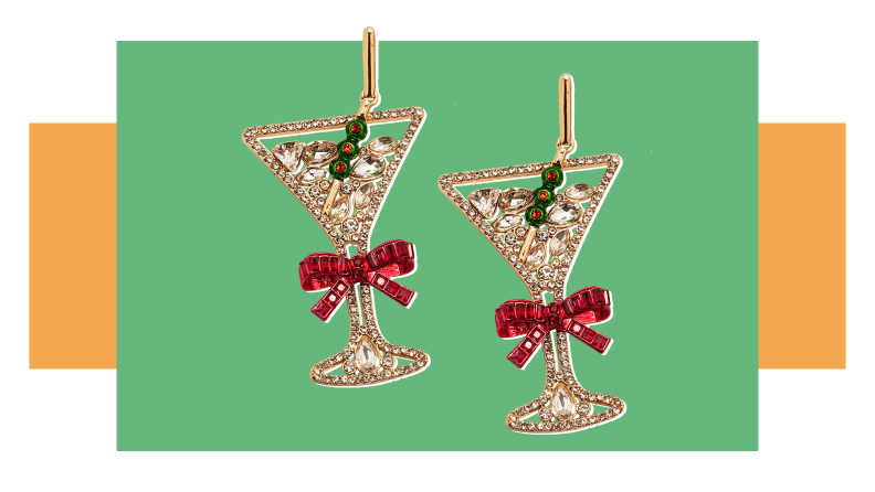 A pair of rhinestone earrings that look like martini glasses with bows on them.