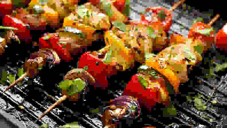 Vegetable skewers cooknig on a grill