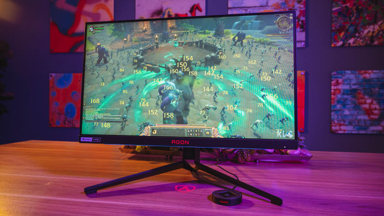 A gaming monitor on top of a wooden desk.