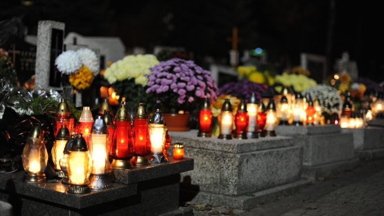 Candles and flowers adorn the graves of loved ones on Dia de Los Muertos.