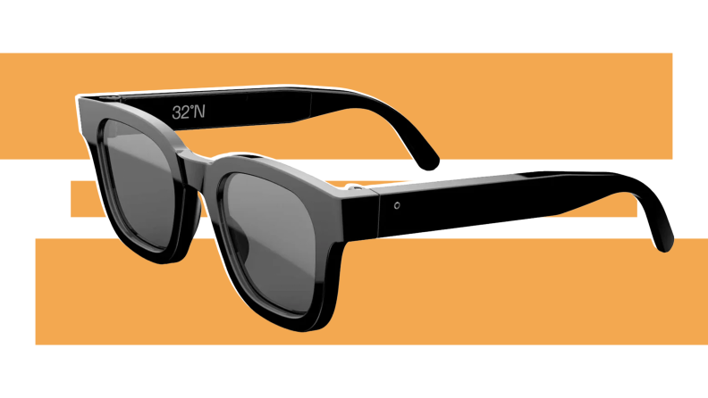 A pair of black 32ºN Adaptive Focus glasses on a green and white background.