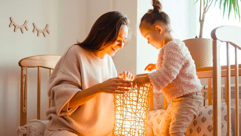 A parent and child look into a light display.