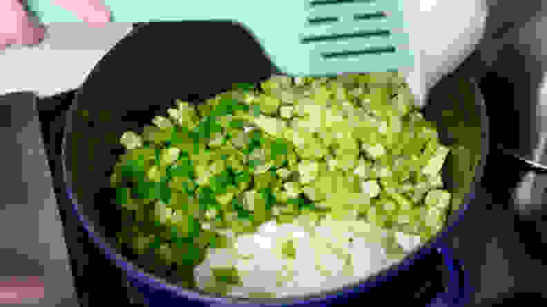 A pot of freshly diced bell pepper, onion, and celery cooking together.