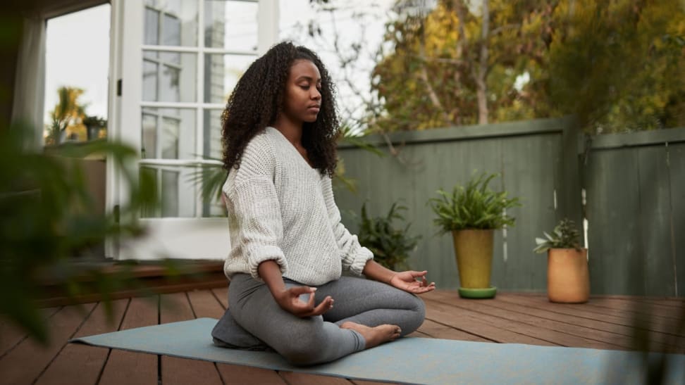 a woman sits on her deck meditating