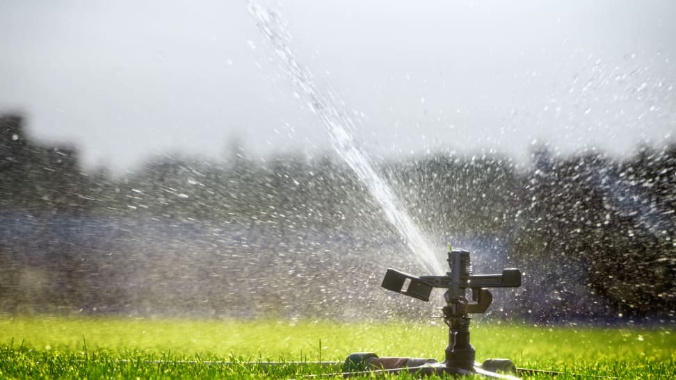 Automatic watering system sprays water on a lawn.