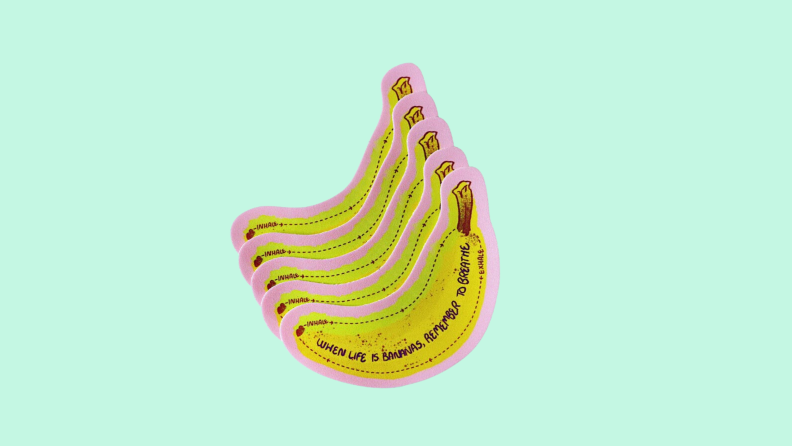 Front view of yellow sensory stickers from Calm Strips Bananas on a light teal background.