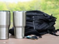 An Ozark Trail tumbler and a Yeti rambler sitting on a table.