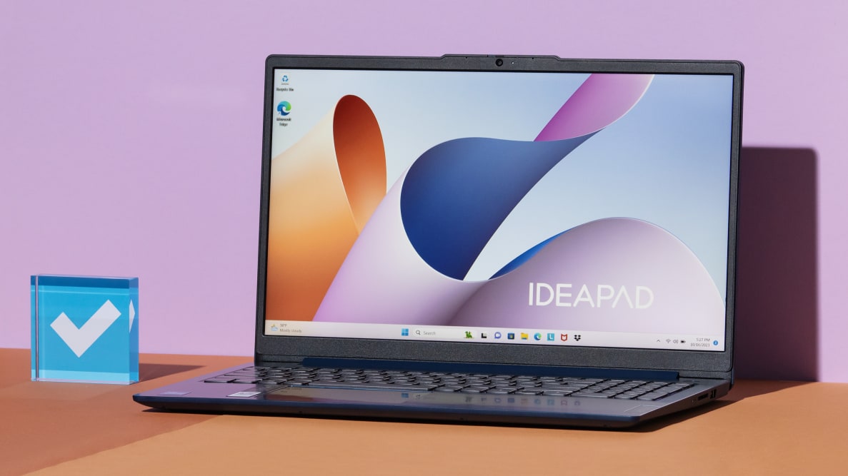 An open and powered on laptop against a pastel purple background.