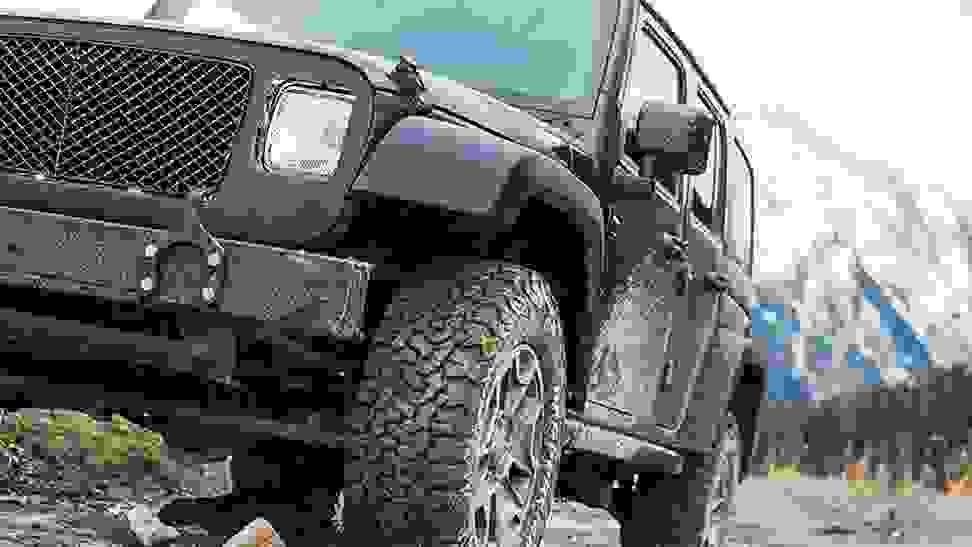 A black Jeep drives through the mud on a set of BFGoodrich off-road tires.