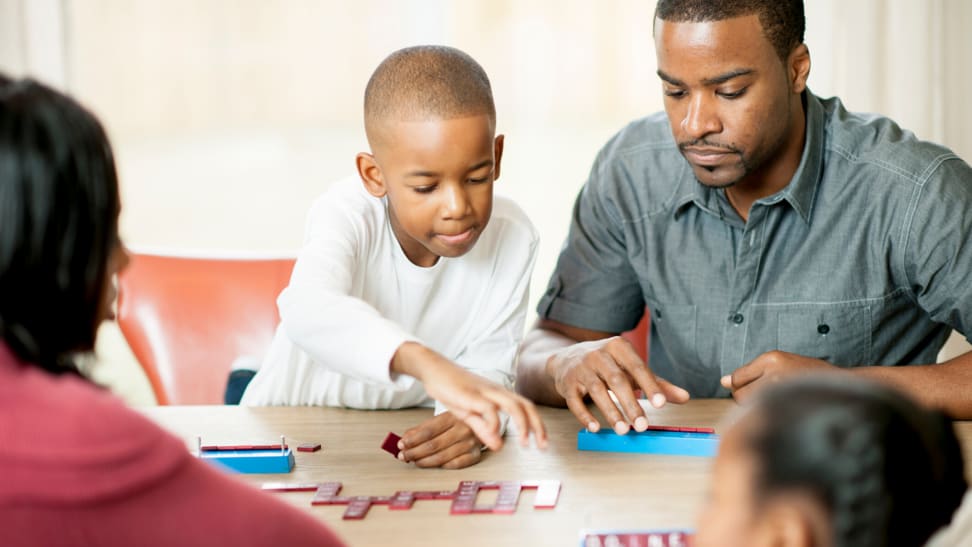 Family playing a game around the table