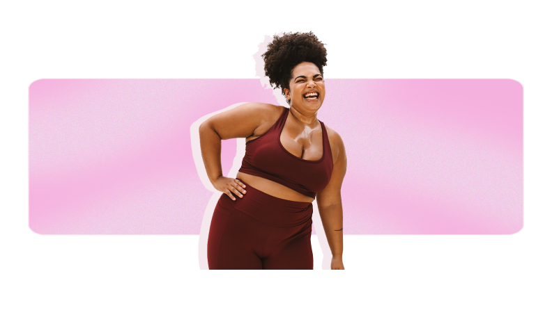 A person wearing a maroon activewear set smiles and has their hand on their hip.