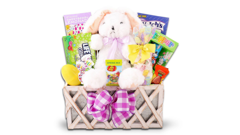 A wooden Easter basket with a stuffed white bunny and candy.