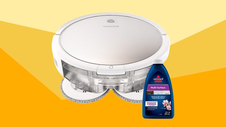 A white Bissell robot vacuum with a bottle of Bissell floor cleaner against a varied yellow background.