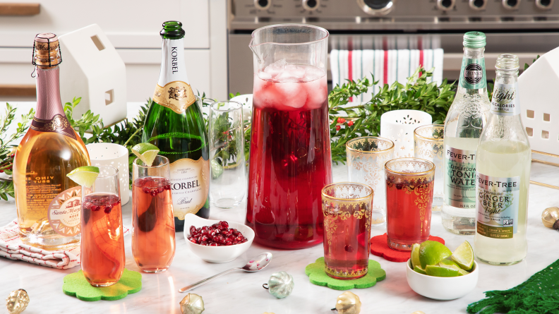 A spread of sparkling wine bottles, juices, and flutes of drinks on a festive countertop