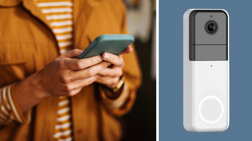 A person checking their phone next to a display of a smart doorbell.