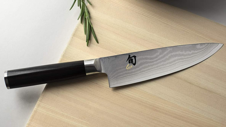 A Shun knife sitting on a wooden cutting board