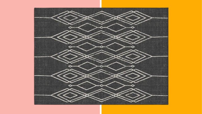 An outdoor rug against a pink and orange background.