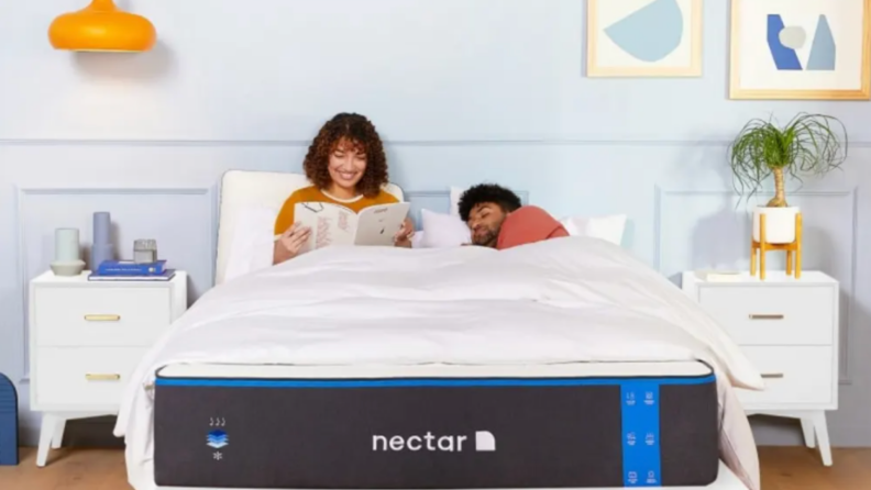 Two people sitting in bed. Nectar mattress pictured in photo.