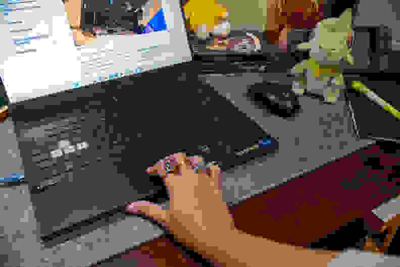 A person's hand on top of a laptop touchpad