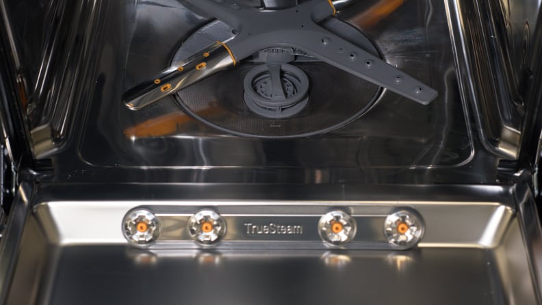 A close-up of the inside of the dishwasher's door, which has four steam nozzles towards the bottom.