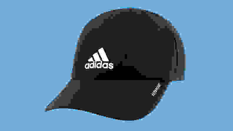 Adidas Men’s Superlite Relaxed Fit Performance hat on a blue background.