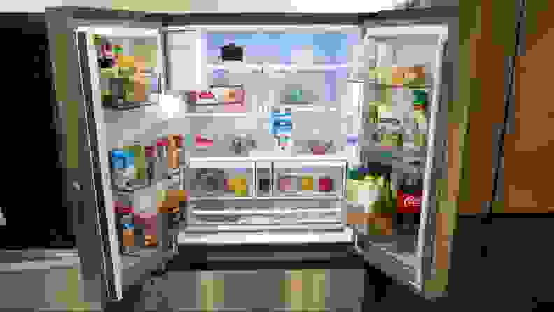 A close-up of the open refrigerator compartment of the fridge, with its shelves and bins fully stocked with food.
