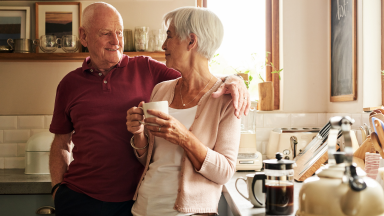 A senior couple spends quality time in their kitchen together.