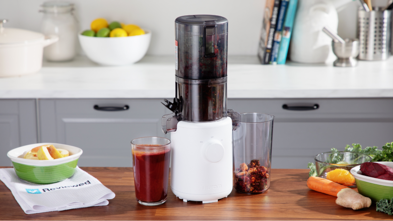 The Hurom 310A juicer atop a table surrounded by fruits.