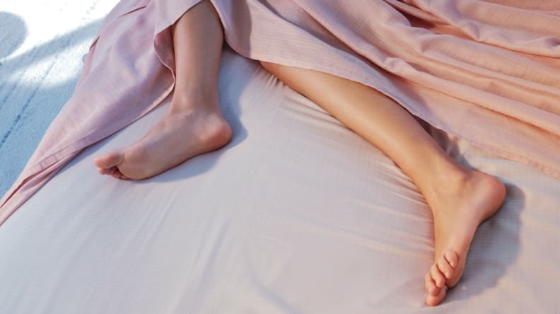 someone in bed on the Casper Hyperlite sheets