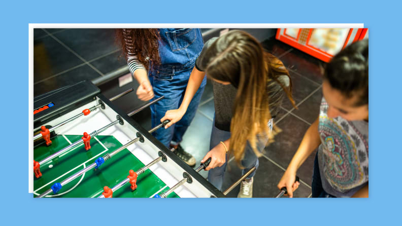 A group of teens playing fooseball.