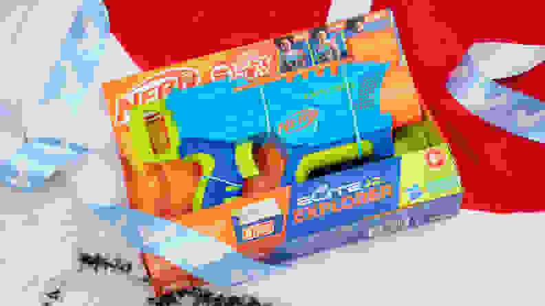 A Nerf gun package on top of ribbon and gift wrap.
