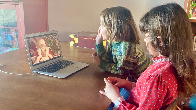 A boy and a girl watching Santa on a laptop