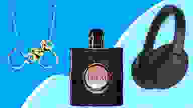 镀金项链，黑色/粉色香水瓶和黑色无线耳机在蓝色漩涡背景