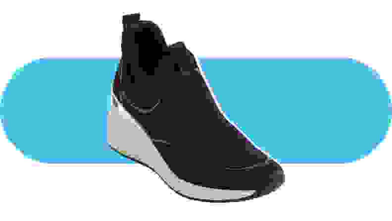 A black slip-on sneaker with a white wedge heel.