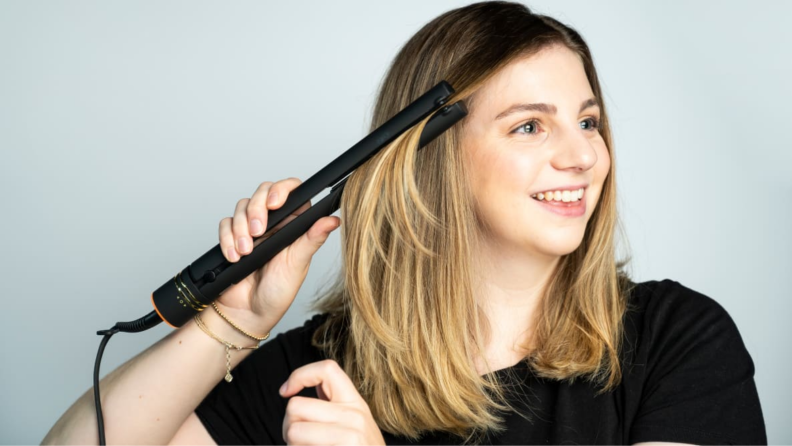 An image of a woman using a Hot Tools straightener