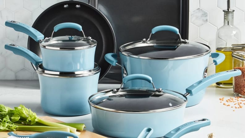 Pastel blue Rachel Ray cookware set on kitchen countertop next to celery on cutting board.