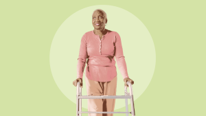 An older woman standing and leaning on a walker.