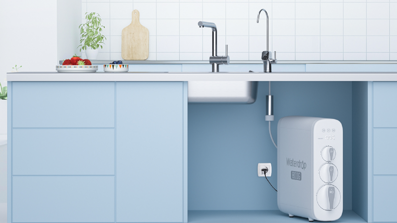 White, rectangular water filter under a sink on a pale blue countertop