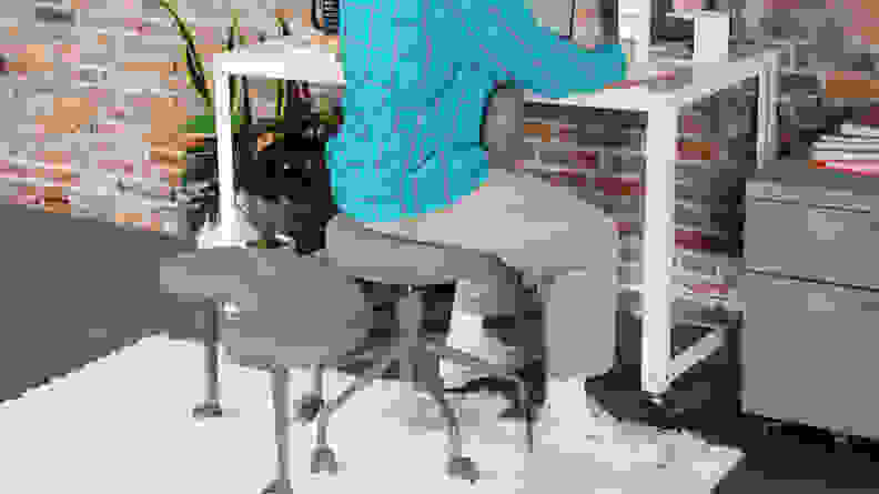 Person sitting backwards in the Pipersong Meditation Chair while working at desk on laptop computer.