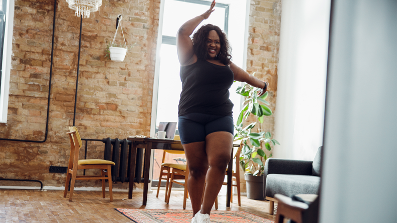 A woman exercises in her apartment