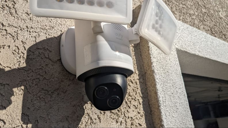 The Eufy Floodlight Camera E340 shown mounted on the exterior of a beige home.