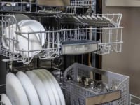A Bosch dishwasher with its middle and upper racks open.