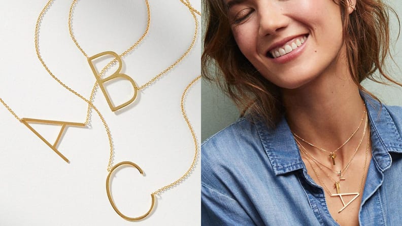 A person wears monogram jewelry with the letter A in gold.