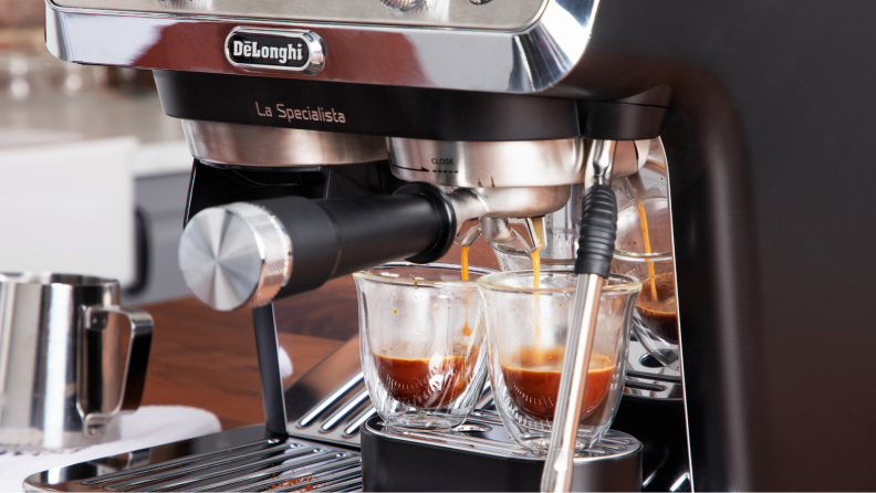 Two cups being filled by the espresso maker.