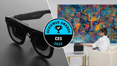 A composite image featuring the XREAL One Pro smart glasses on the left and a colorful abstract digital art display being projected on a wall on the right, with a woman interacting with the projection device, highlighted by a "CES 2025 Reviewed Awards" badge in the center.