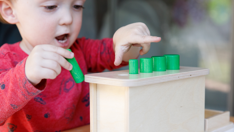 A child plays with a cylinder game.