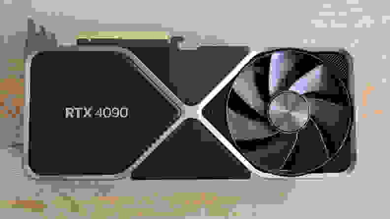 A black and silver graphics card lying flat on a wooden table.